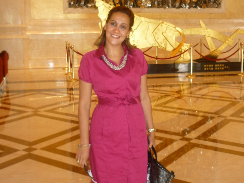 Jana buicki de vestido rosa e bolsa na mão